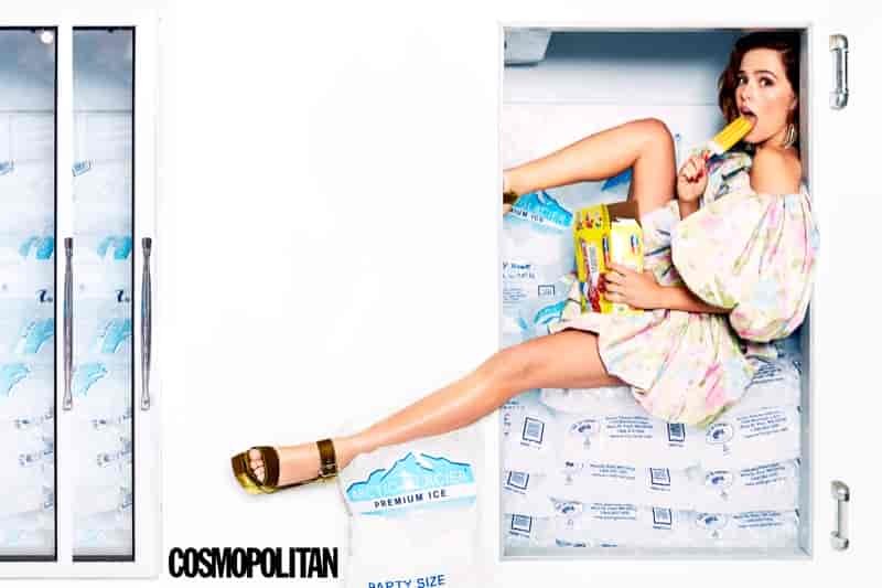 Eating a popsicle, Zoey Deutch wears The Marc Jacobs dress, Jimmy Choo sandals and Area earrings