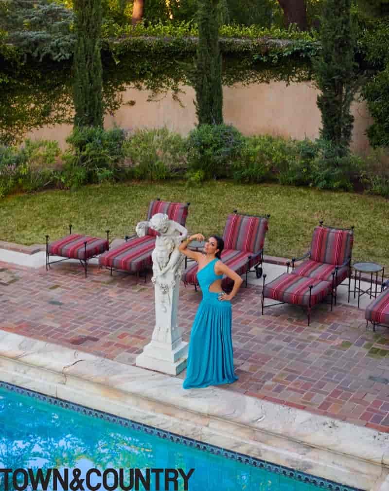 Posing poolside, Eva Longoria wears a blue dress.