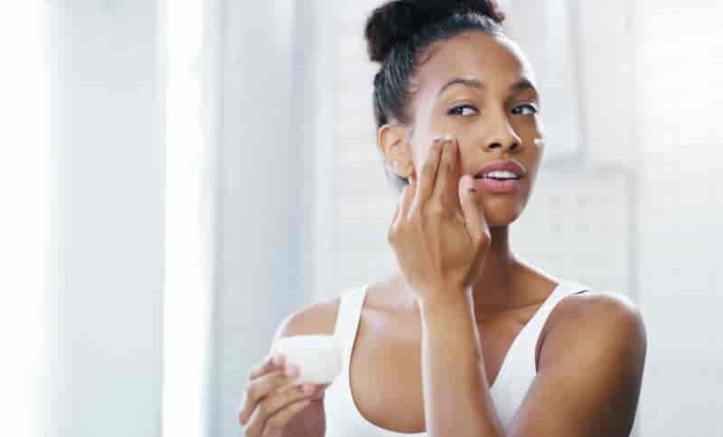 Woman applying face cream